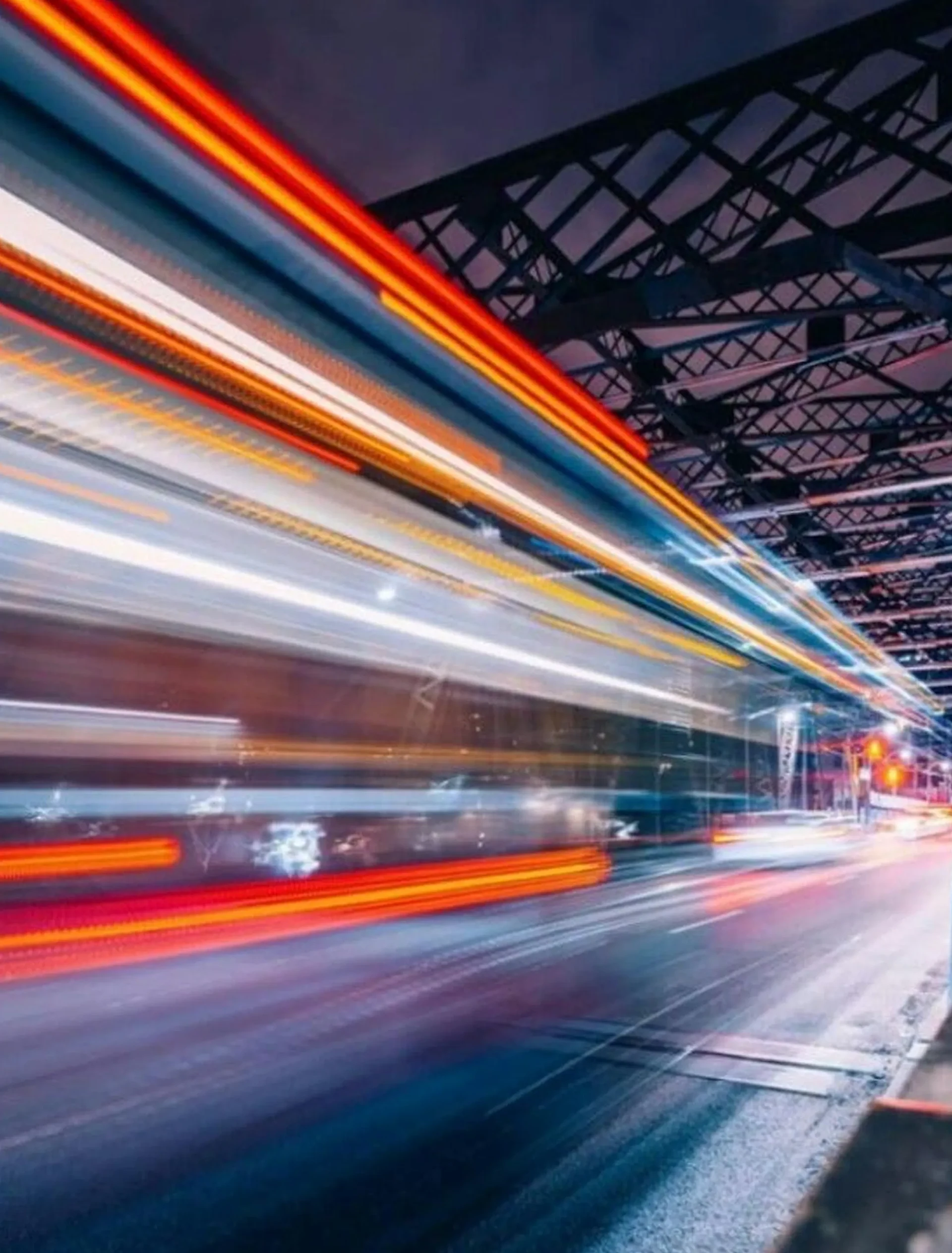 Estelas de luz de un tren cruzando la ciudad de noche